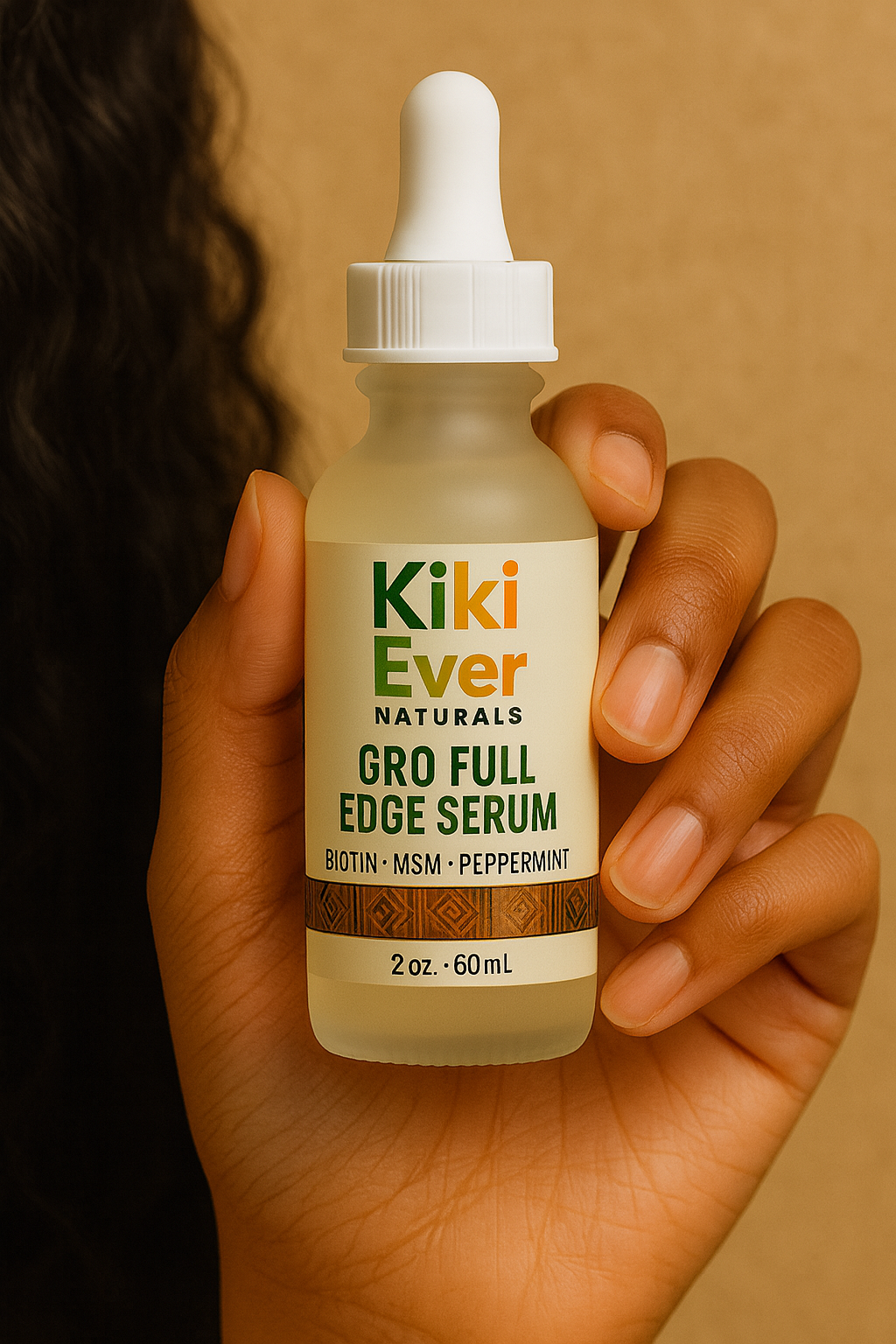 Hand holding a bottle of Kiki Ever Naturals Gro Full Edge Serum against a brown background